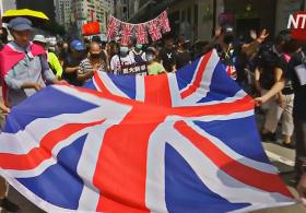 Протестующие Гонконга шли по улицам с британскими флагами