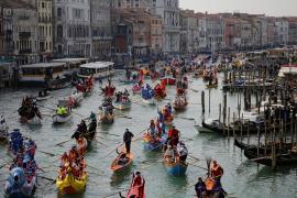 Венецианский карнавал: гондольеры в костюмах и туристы в масках