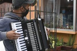 Чилиец играет на аккордеоне перед окнами самозолировавшихся родителей