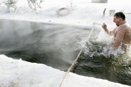 Россияне окунаются в ледяную воду, отмечая Крещение