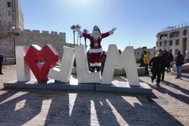 Санта-Клаус раздаёт ёлки перед Рождеством в Иерусалиме