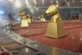 Гости фестиваля льда и снега в Харбине греются у огромного хот-пота